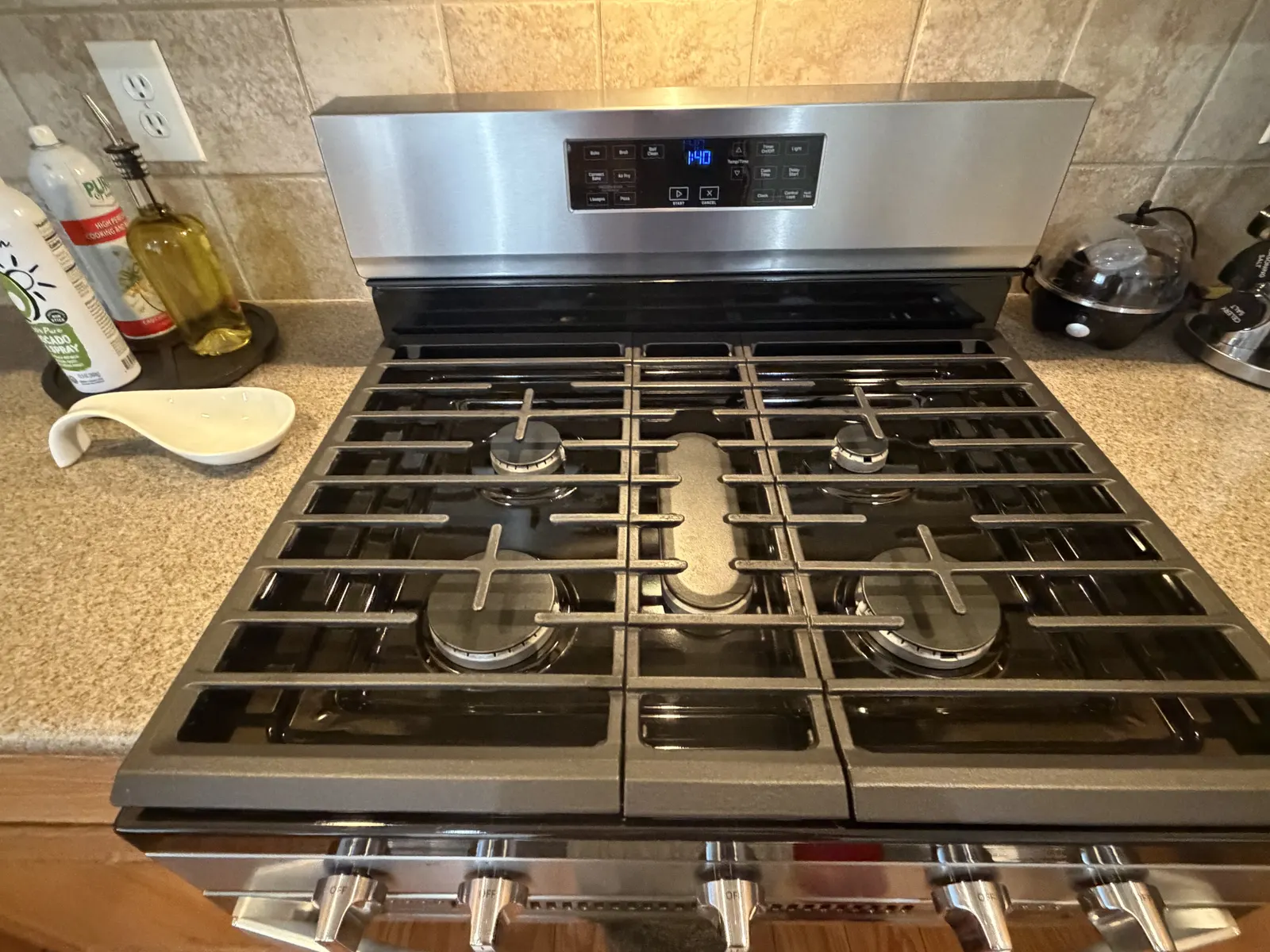 The same stovetop after cleaning, with the grates and steel surface clean
